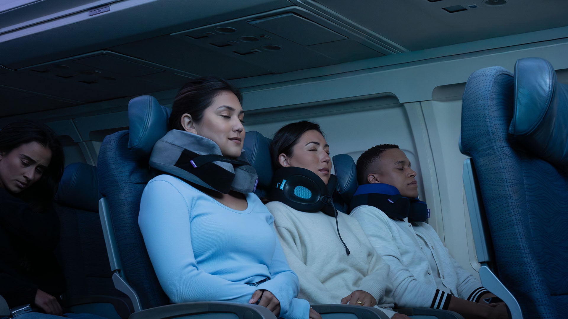 Three people sleeping using Cabeau necks pillows on a flight